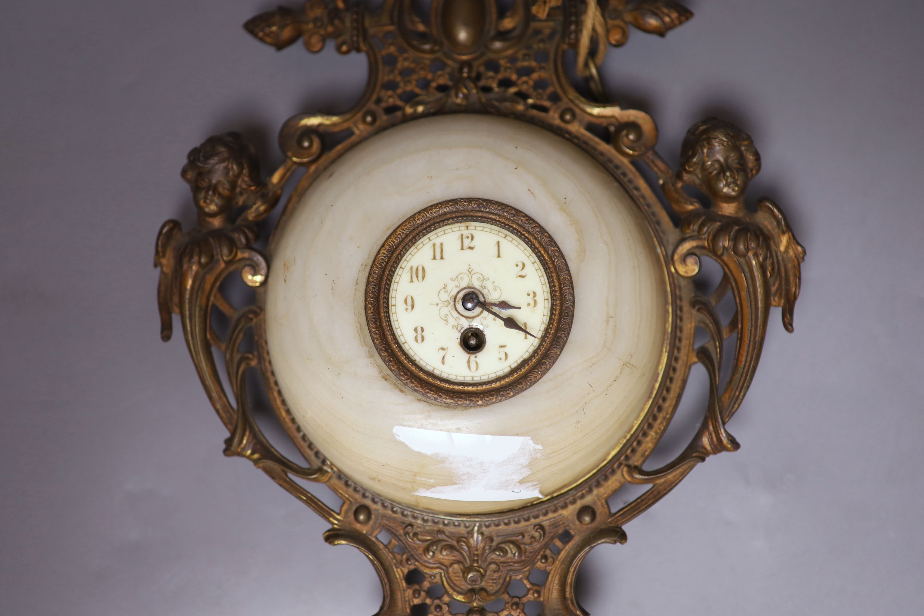 A French gilt metal, onyx and enamelled wall clock, length 49cm